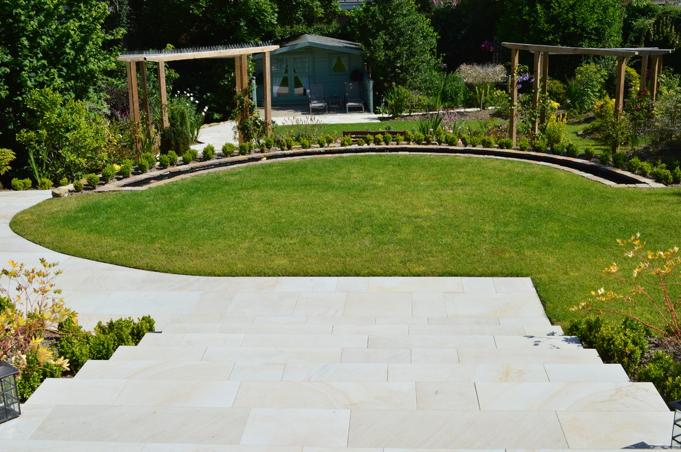 This is an example of a traditional backyard garden in West Midlands with a vertical garden and natural stone pavers.