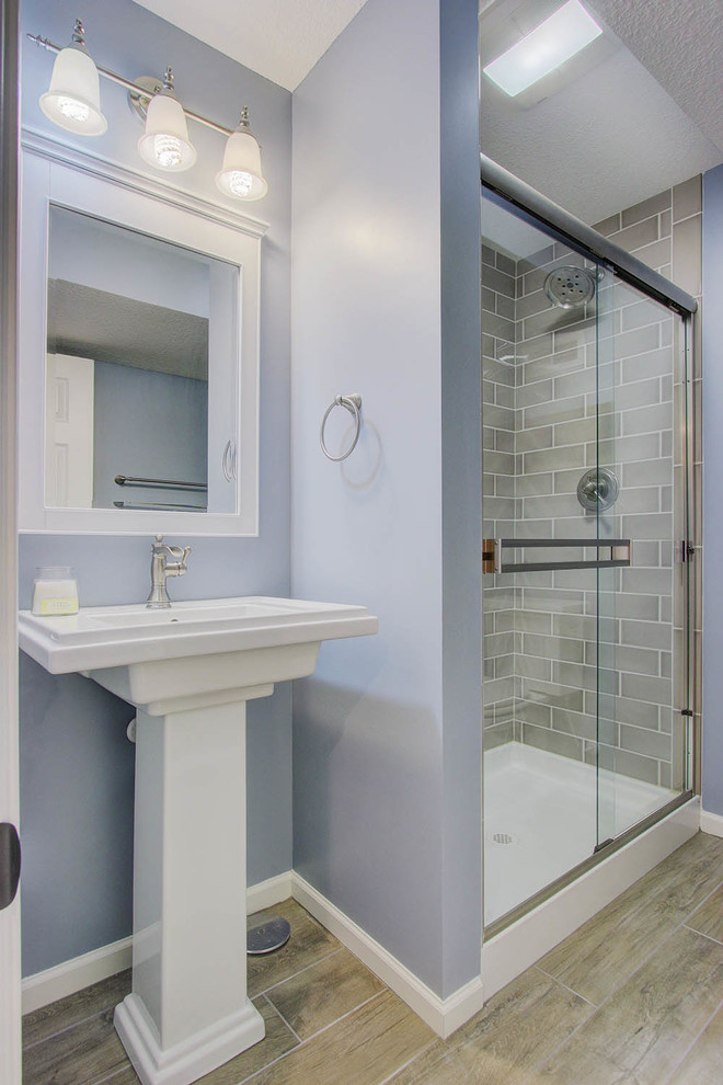 Design ideas for a small transitional 3/4 bathroom in Kansas City with an alcove shower, subway tile, blue walls, a pedestal sink and gray tile.