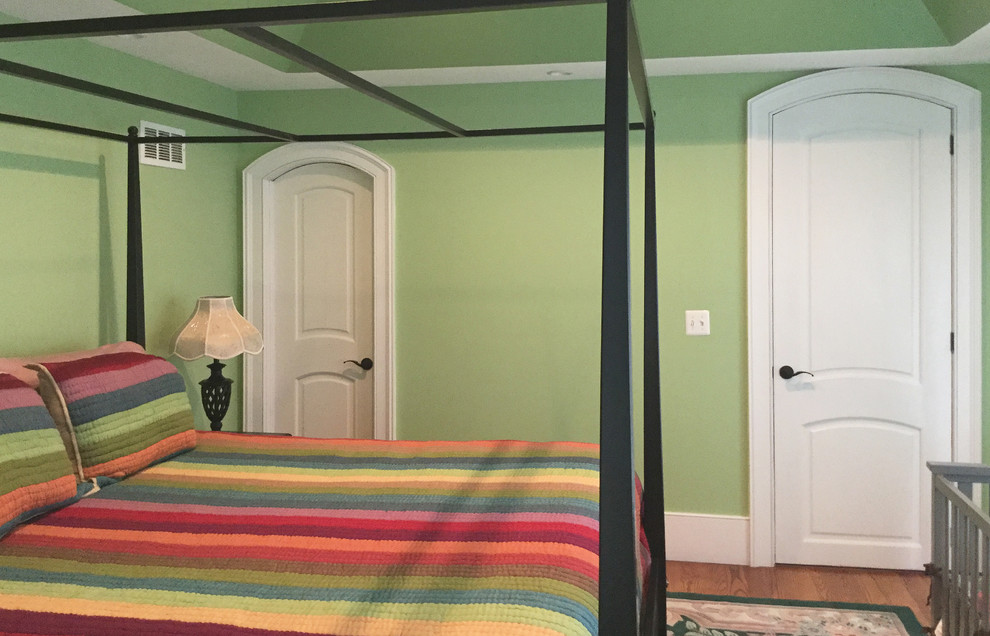 This is an example of a traditional master bedroom in Other with green walls, medium hardwood floors and brown floor.
