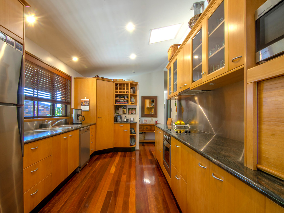 Inspiration for a mid-sized contemporary galley separate kitchen in Sunshine Coast with a single-bowl sink, flat-panel cabinets, light wood cabinets, granite benchtops, metallic splashback, stainless steel appliances and medium hardwood floors.