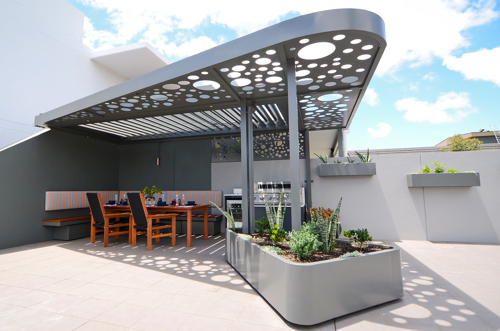 Photo of a contemporary patio in Sydney with a container garden and an awning.