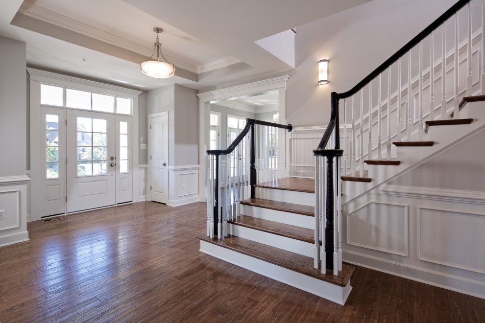 Traditional foyer in Baltimore with a single front door, a white front door, brown floor, recessed, decorative wall panelling and white walls.