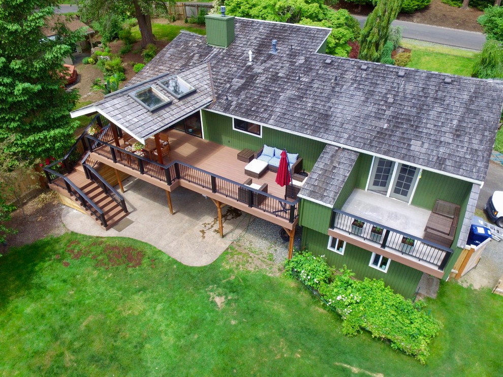 This is an example of a large contemporary backyard deck in Seattle with a roof extension.