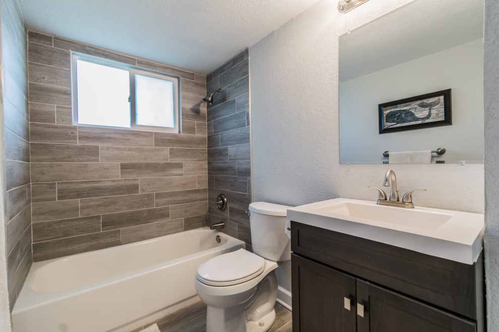This is an example of a small beach style kids bathroom in Tampa with shaker cabinets, brown cabinets, wood-look tile, engineered quartz benchtops, white benchtops, a single vanity and a freestanding vanity.