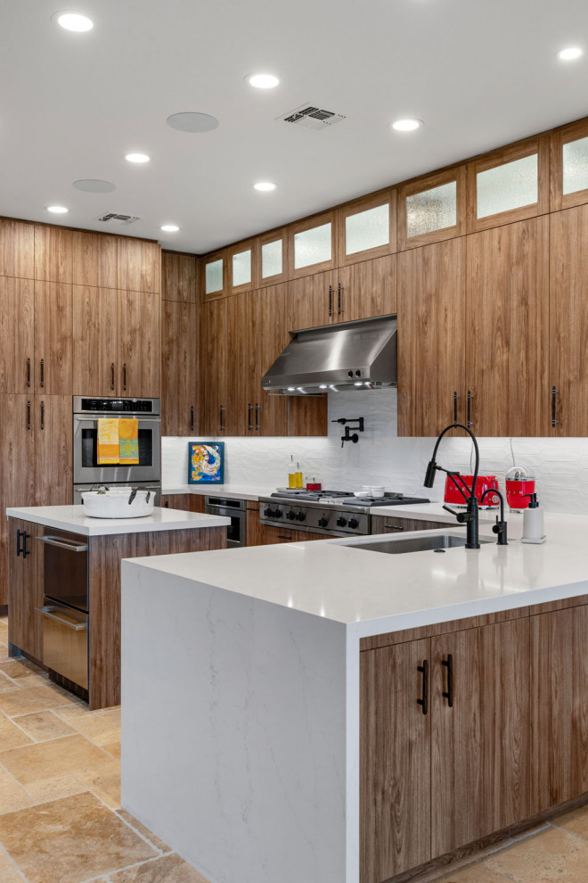 Mountain style l-shaped slate floor and beige floor enclosed kitchen photo with a single-bowl sink, flat-panel cabinets, medium tone wood cabinets, quartzite countertops, white backsplash, glass sheet backsplash, stainless steel appliances, a peninsula and white countertops