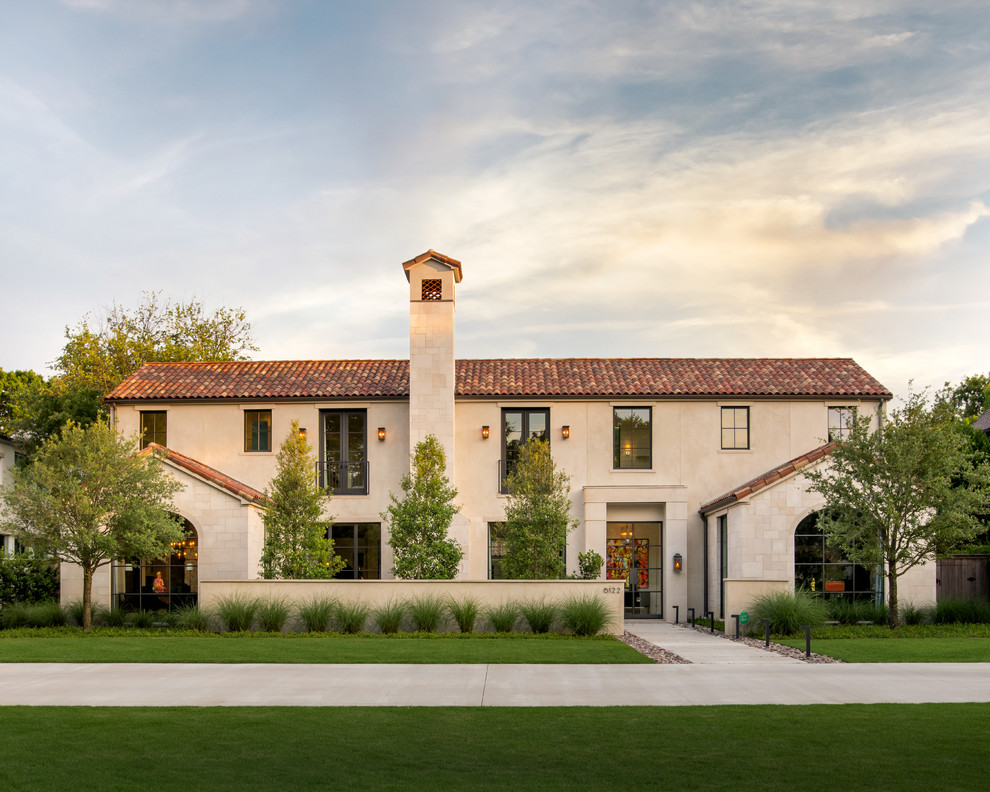 Inspiration for a mediterranean beige two-story gable roof remodel in Dallas with a tile roof