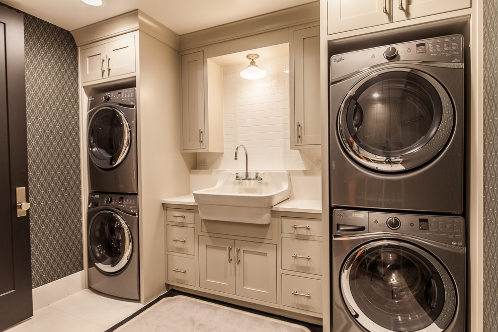 Mid-sized transitional single-wall dedicated laundry room in Las Vegas with shaker cabinets, beige cabinets, grey walls, a stacked washer and dryer, ceramic floors, beige floor, white benchtop and a drop-in sink.