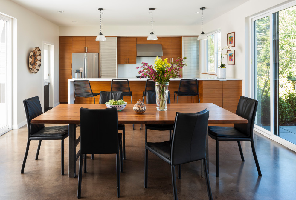 Contemporary dining room in Seattle with white walls, concrete floors and brown floor.