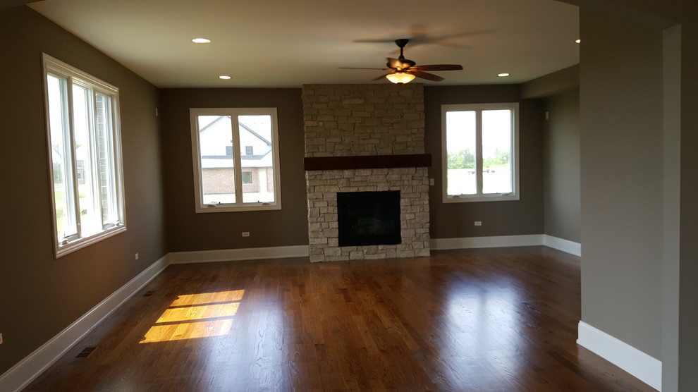 Transitional living room in Chicago with medium hardwood floors, a standard fireplace and a stone fireplace surround.