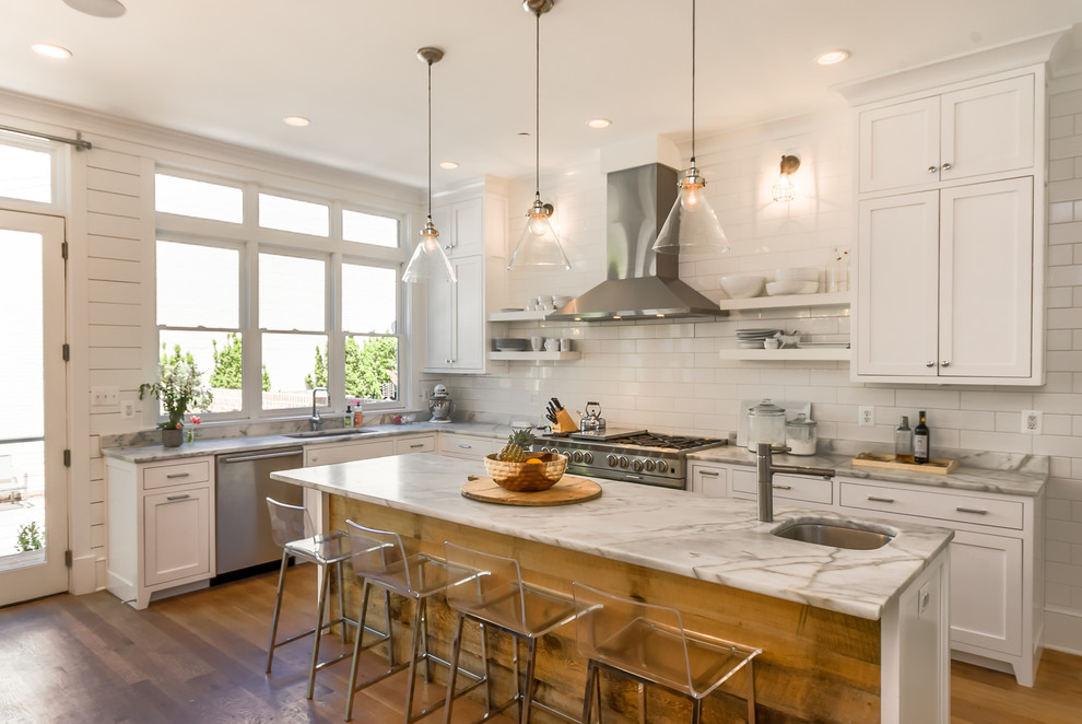 Inspiration for a country l-shaped eat-in kitchen in DC Metro with an undermount sink, shaker cabinets, white cabinets, white splashback, subway tile splashback, stainless steel appliances, medium hardwood floors, with island and brown floor.