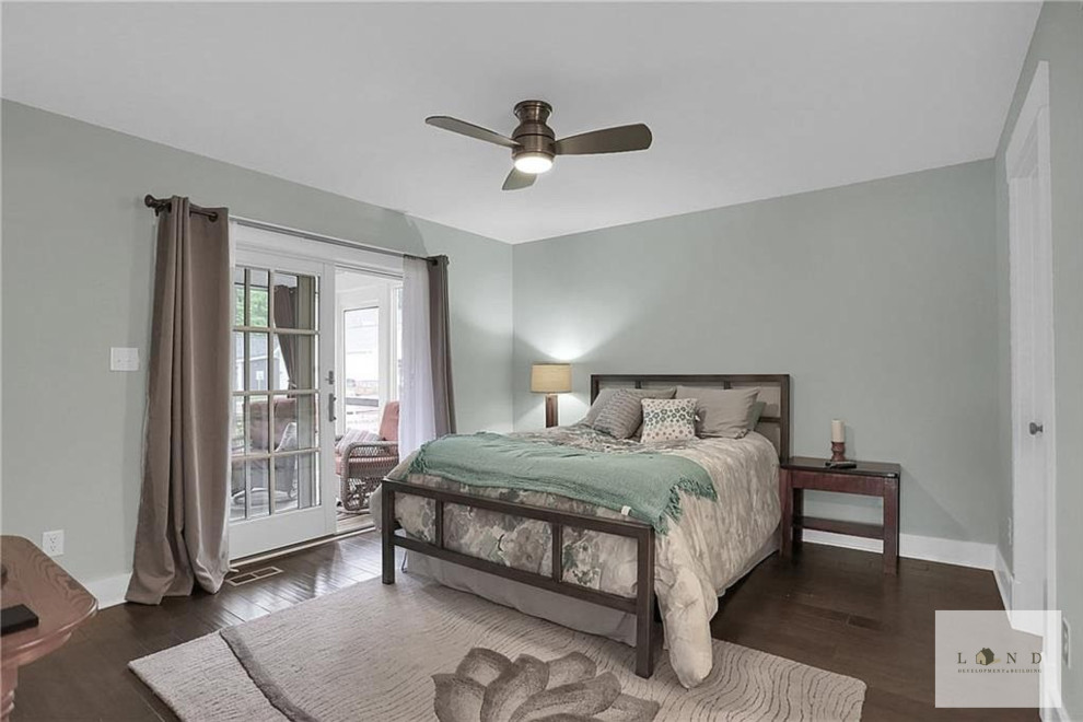 Ejemplo de dormitorio principal de estilo americano de tamaño medio con paredes verdes y suelo de madera oscura