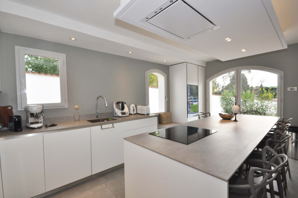 Design ideas for a large contemporary l-shaped open plan kitchen in Lyon with white cabinets, stainless steel appliances, with island, grey floor, grey splashback, grey benchtop, an undermount sink, beaded inset cabinets, quartzite benchtops, granite splashback, concrete floors and recessed.