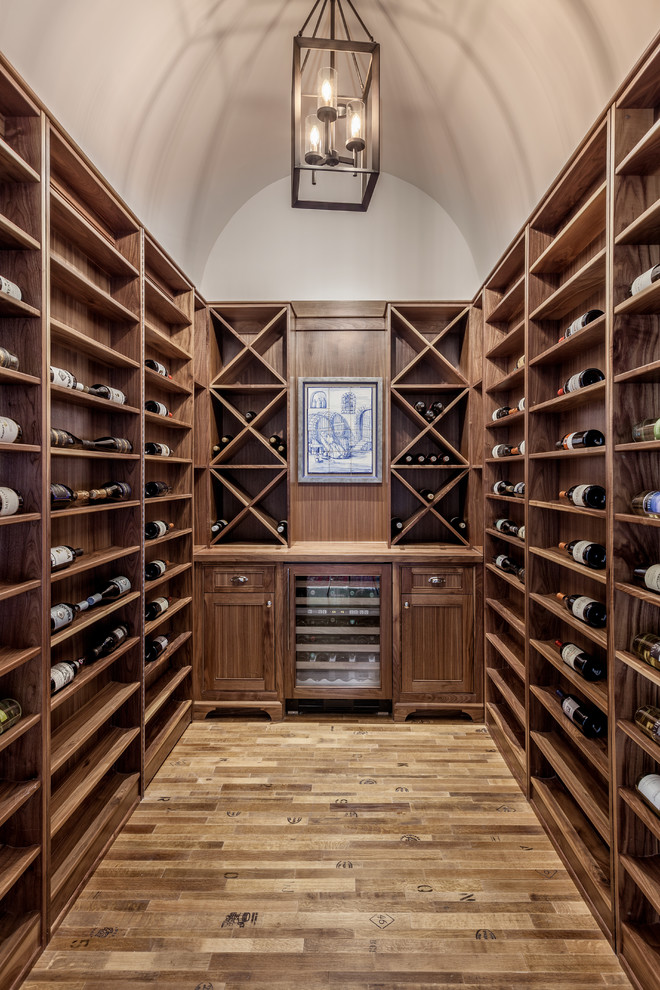 Large traditional wine cellar in Other with cork floors and display racks.