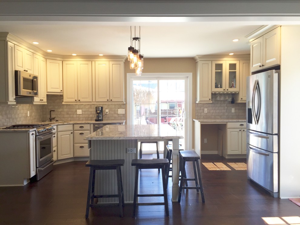 Inspiration for a large transitional u-shaped dark wood floor and brown floor eat-in kitchen remodel in Atlanta with an undermount sink, raised-panel cabinets, beige cabinets, granite countertops, beige backsplash, glass tile backsplash, stainless steel appliances, an island and beige countertops