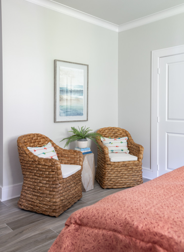 Ejemplo de habitación de invitados costera de tamaño medio con paredes grises, suelo de baldosas de porcelana y suelo marrón
