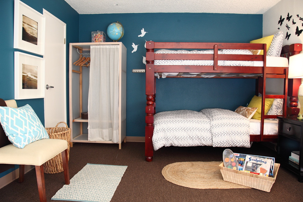 This is an example of a contemporary gender-neutral kids' bedroom for kids 4-10 years old in Los Angeles with blue walls and carpet.