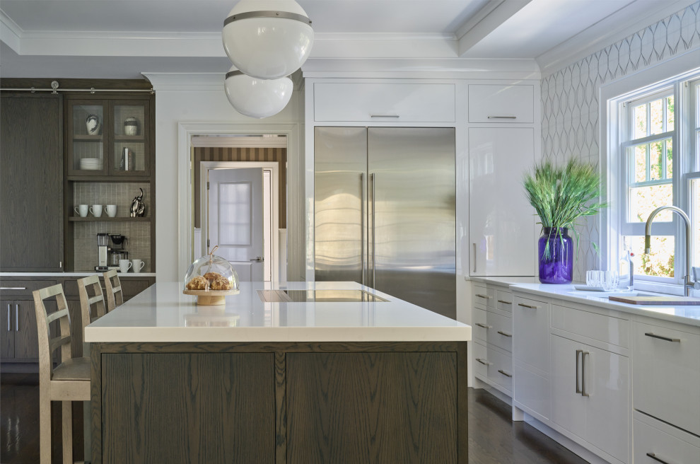 Large transitional u-shaped dark wood floor and brown floor enclosed kitchen photo in New York with an undermount sink, flat-panel cabinets, dark wood cabinets, quartz countertops, white backsplash, mosaic tile backsplash, stainless steel appliances, an island and white countertops