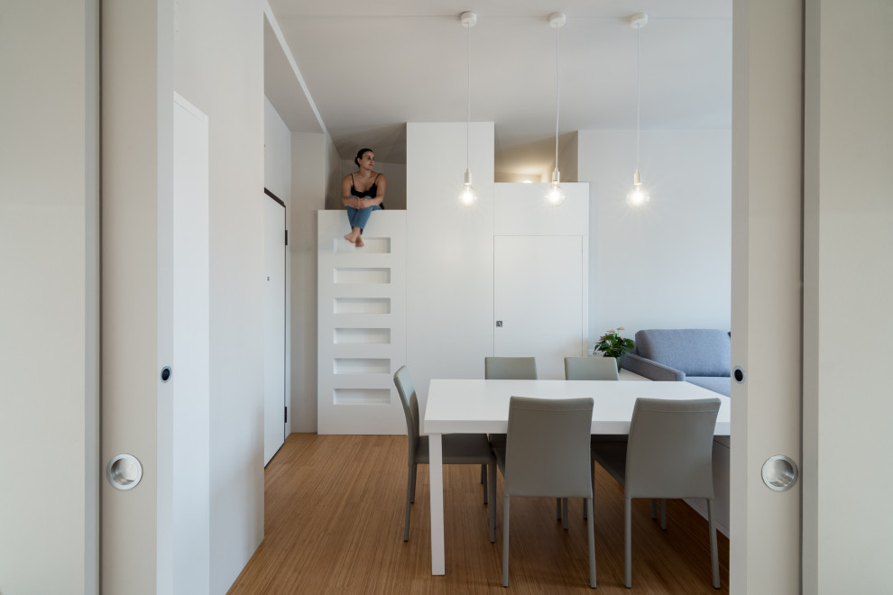Стильный дизайн: маленькая гостиная-столовая в современном стиле с серыми стенами, полом из бамбука и панелями на части стены для на участке и в саду - последний тренд