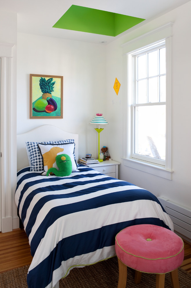 Photo of a traditional gender-neutral kids' bedroom for kids 4-10 years old in DC Metro with white walls and medium hardwood floors.