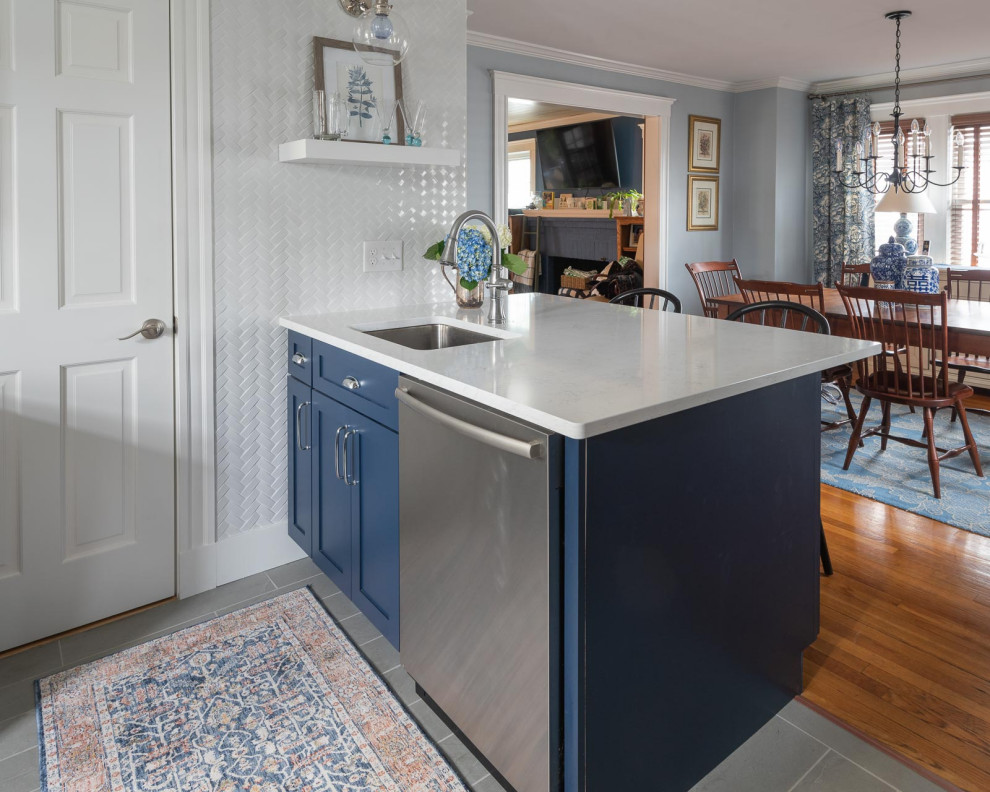 Mid-sized transitional u-shaped porcelain tile and gray floor eat-in kitchen photo in Boston with an undermount sink, shaker cabinets, blue cabinets, quartz countertops, white backsplash, subway tile backsplash, stainless steel appliances, a peninsula and white countertops