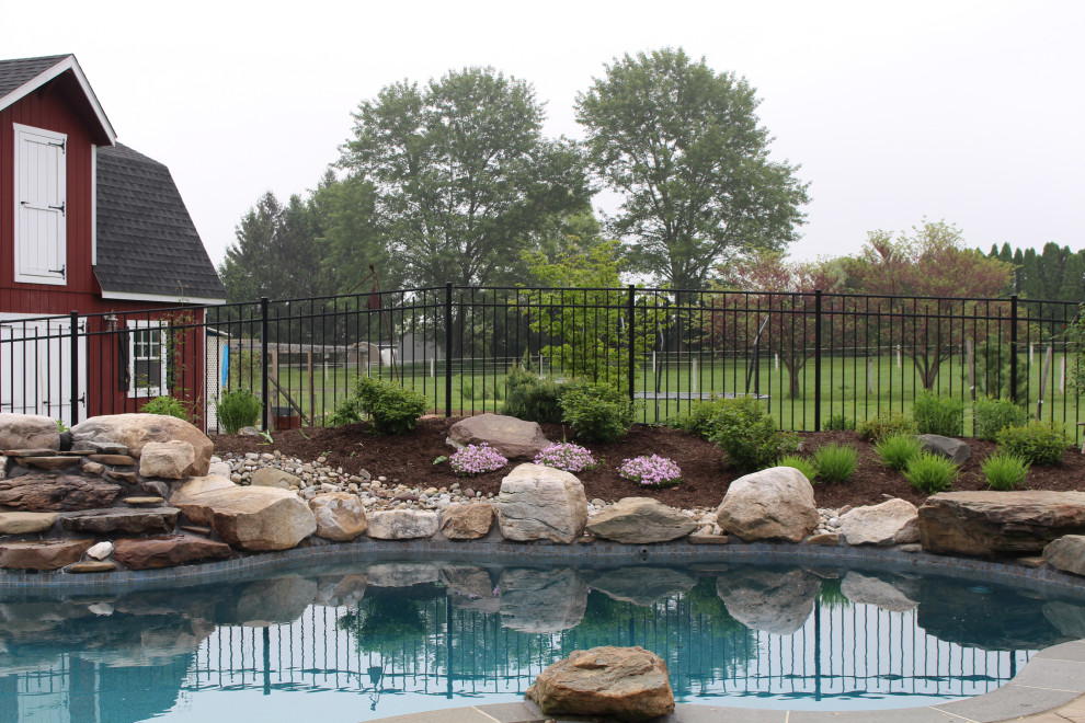 Photo of a large rustic drought-tolerant and full sun backyard concrete paver flower bed for spring.