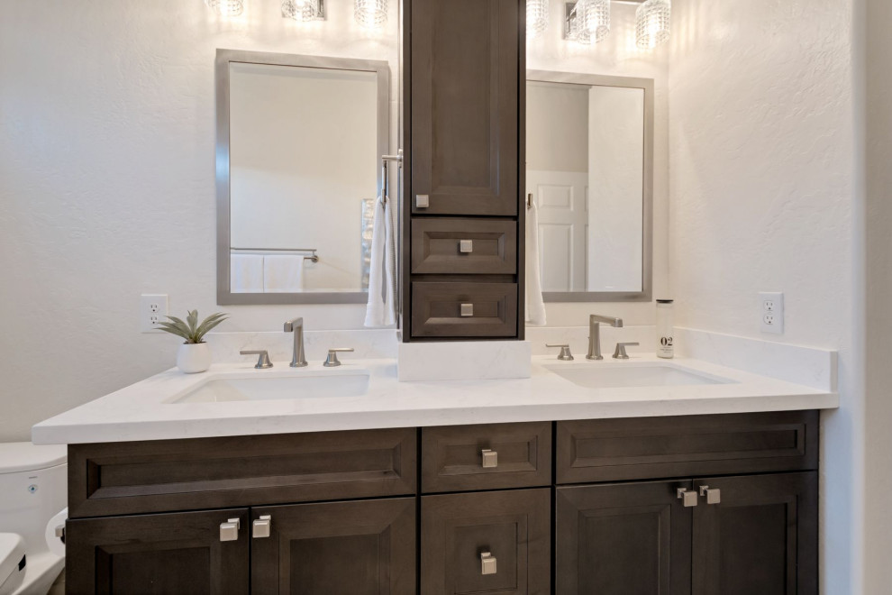 Mid-sized transitional kids bathroom in Phoenix with recessed-panel cabinets, brown cabinets, an alcove tub, a shower/bathtub combo, a bidet, white tile, marble, beige walls, an undermount sink, engineered quartz benchtops, a sliding shower screen, white benchtops, a niche, a double vanity and a built-in vanity.