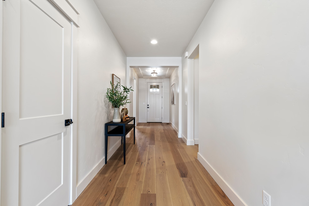 Imagen de puerta principal de estilo americano de tamaño medio con paredes blancas, suelo de madera en tonos medios, puerta simple, puerta blanca y suelo beige