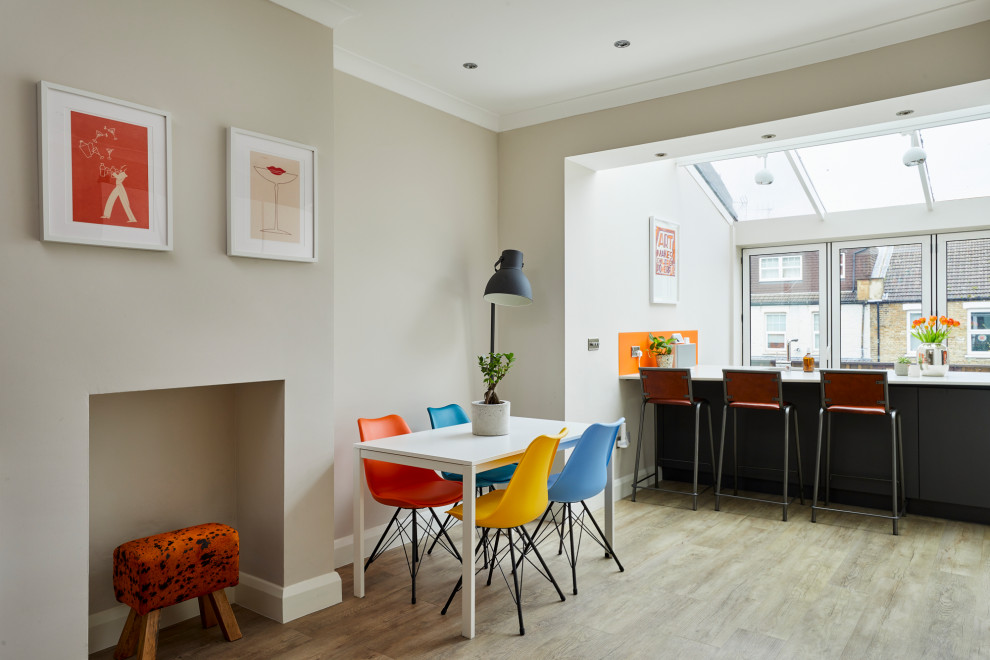 Eat-in kitchen - mid-sized contemporary light wood floor eat-in kitchen idea in London with an undermount sink, flat-panel cabinets, white cabinets, quartz countertops, orange backsplash, glass sheet backsplash, stainless steel appliances, an island and white countertops