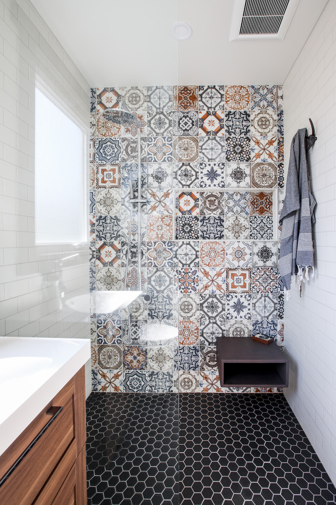 Contemporary 3/4 bathroom in Toronto with shaker cabinets, medium wood cabinets, a curbless shower, a one-piece toilet, multi-coloured tile, subway tile, white walls, a console sink, black floor, an open shower and a shower seat.