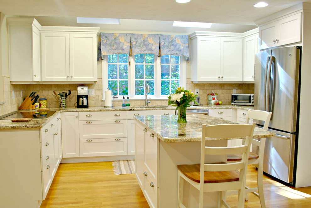 Inspiration for a mid-sized traditional u-shaped eat-in kitchen in Boston with an undermount sink, recessed-panel cabinets, white cabinets, granite benchtops, beige splashback, stainless steel appliances, medium hardwood floors and with island.