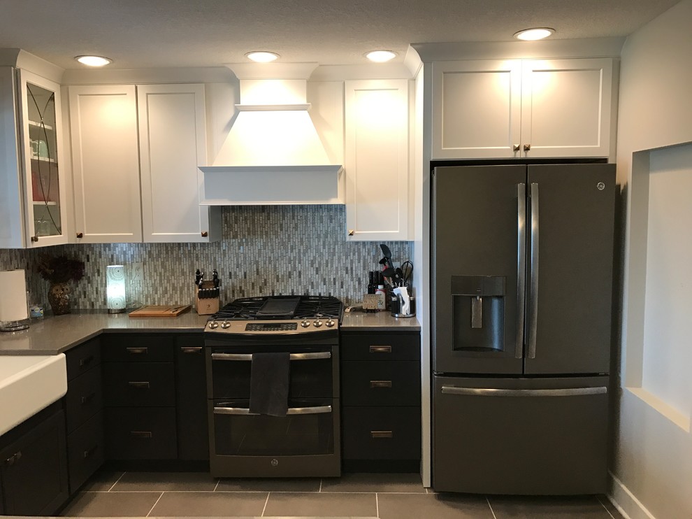 This is an example of a mid-sized contemporary l-shaped eat-in kitchen in Other with a farmhouse sink, recessed-panel cabinets, yellow cabinets, quartz benchtops, multi-coloured splashback, glass tile splashback, stainless steel appliances, bamboo floors, a peninsula and grey floor.