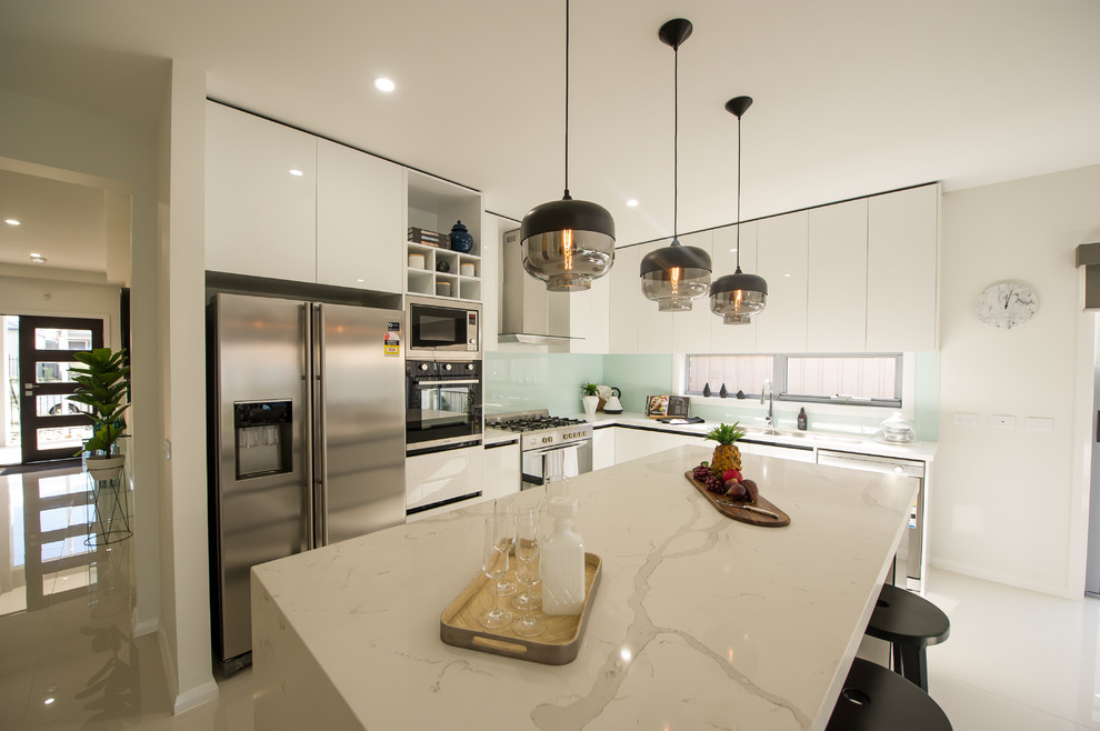 Mid-sized contemporary galley eat-in kitchen in Townsville with an undermount sink, flat-panel cabinets, white cabinets, quartz benchtops, glass sheet splashback, stainless steel appliances, porcelain floors and with island.
