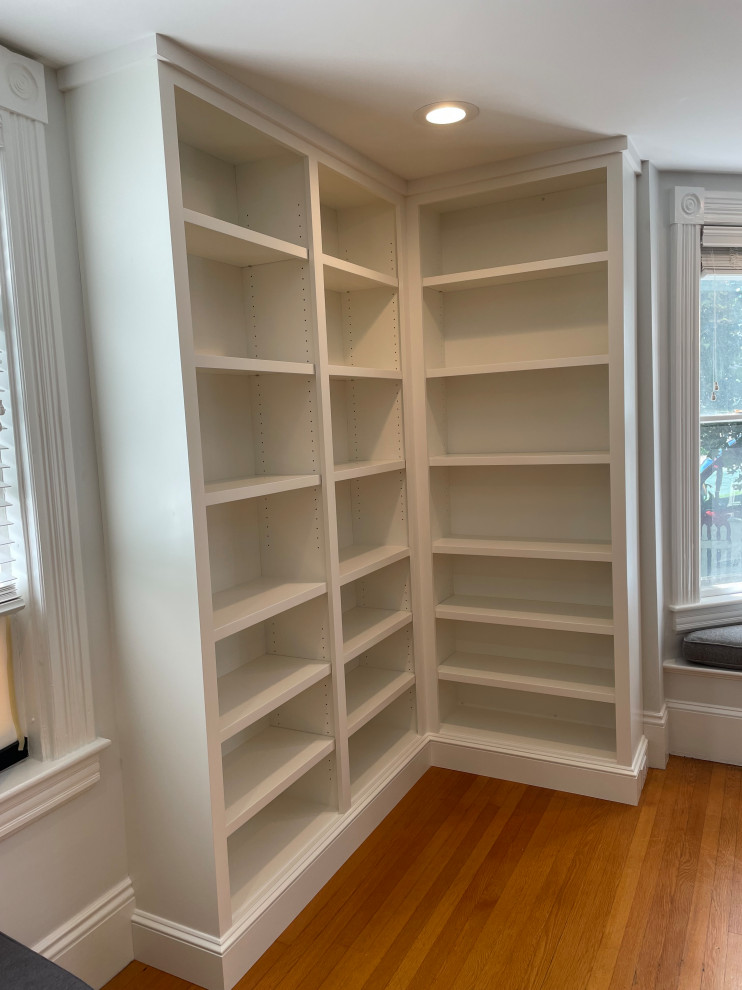 Foto di un soggiorno chic di medie dimensioni e aperto con libreria, pavimento in legno massello medio e porta TV ad angolo