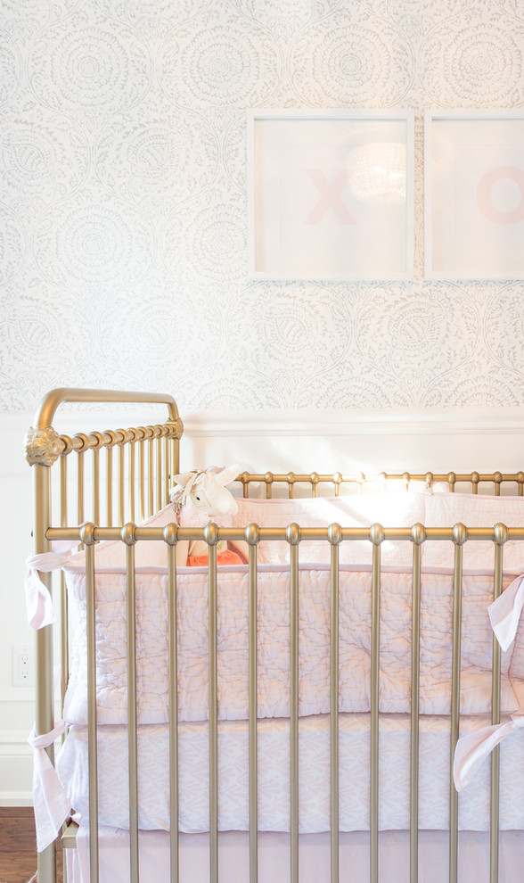 Photo of a large transitional nursery for girls in Toronto with white walls, dark hardwood floors and brown floor.