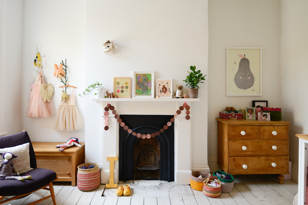 Photo of a scandinavian kids' room for girls in London with beige walls, painted wood floors and white floor.