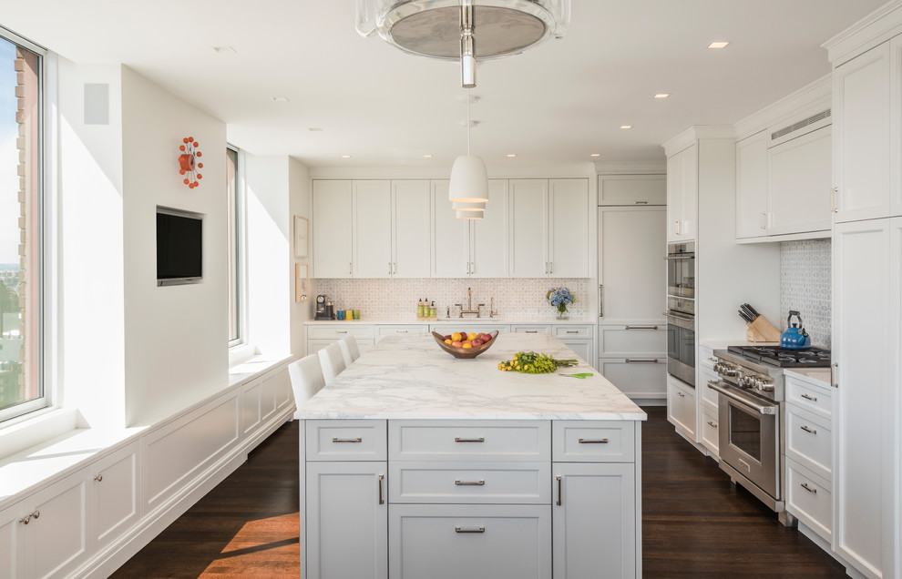 Inspiration for a large transitional kitchen in New York with an undermount sink, shaker cabinets, white cabinets, marble benchtops, with island, brown floor, white splashback, stainless steel appliances, dark hardwood floors and white benchtop.