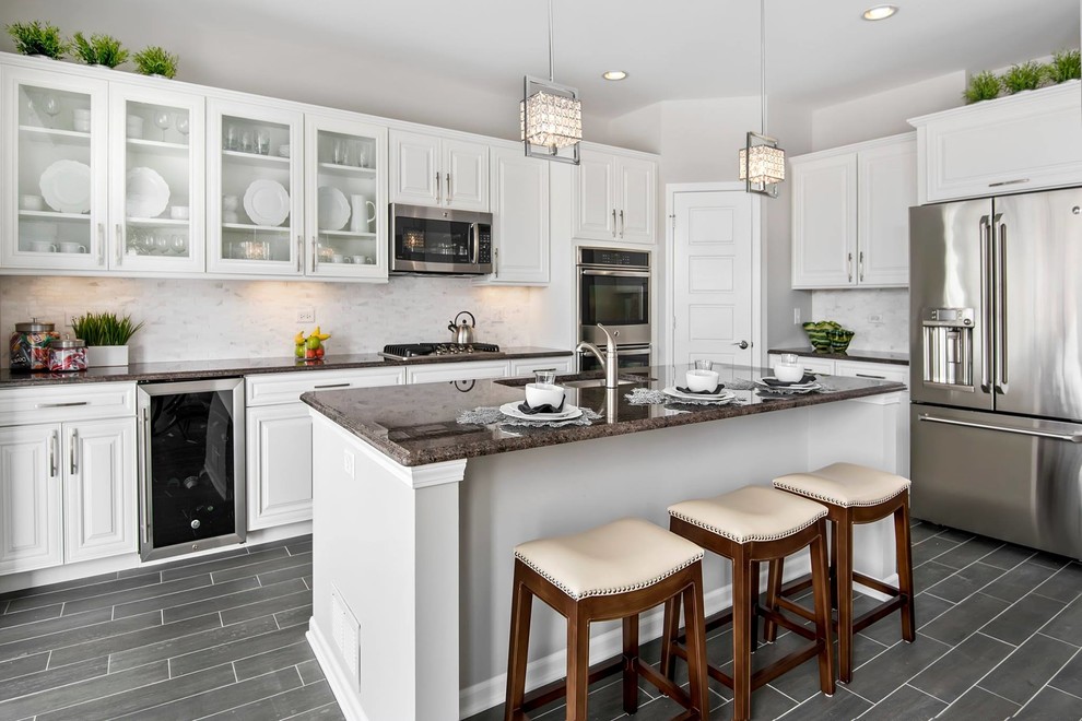 Large transitional l-shaped porcelain tile eat-in kitchen photo in Chicago with raised-panel cabinets, white cabinets, granite countertops, white backsplash, an island, an undermount sink, stone tile backsplash and stainless steel appliances