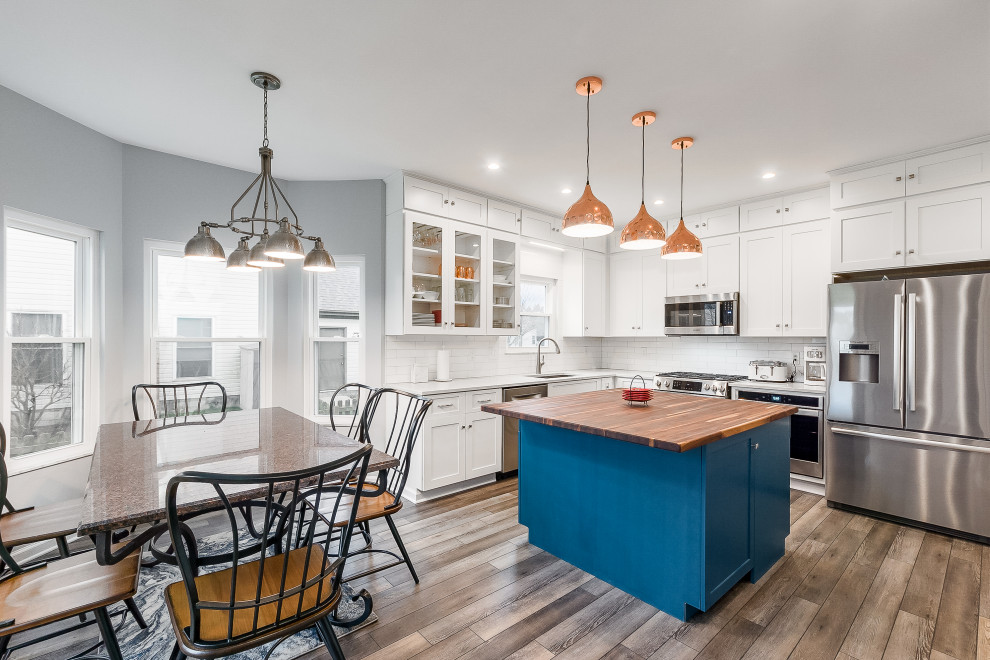 Mid-sized transitional l-shaped eat-in kitchen photo in Columbus with shaker cabinets, quartz countertops, white backsplash, subway tile backsplash and an island