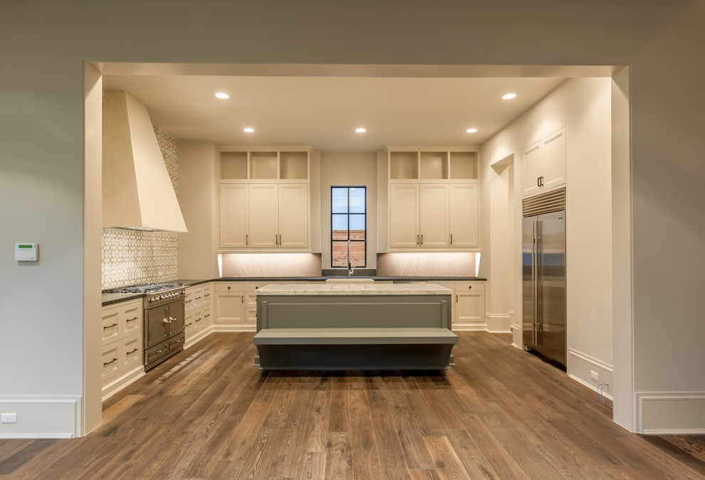 Large transitional l-shaped medium tone wood floor eat-in kitchen photo in Houston with recessed-panel cabinets, marble countertops, beige backsplash, stainless steel appliances and an island