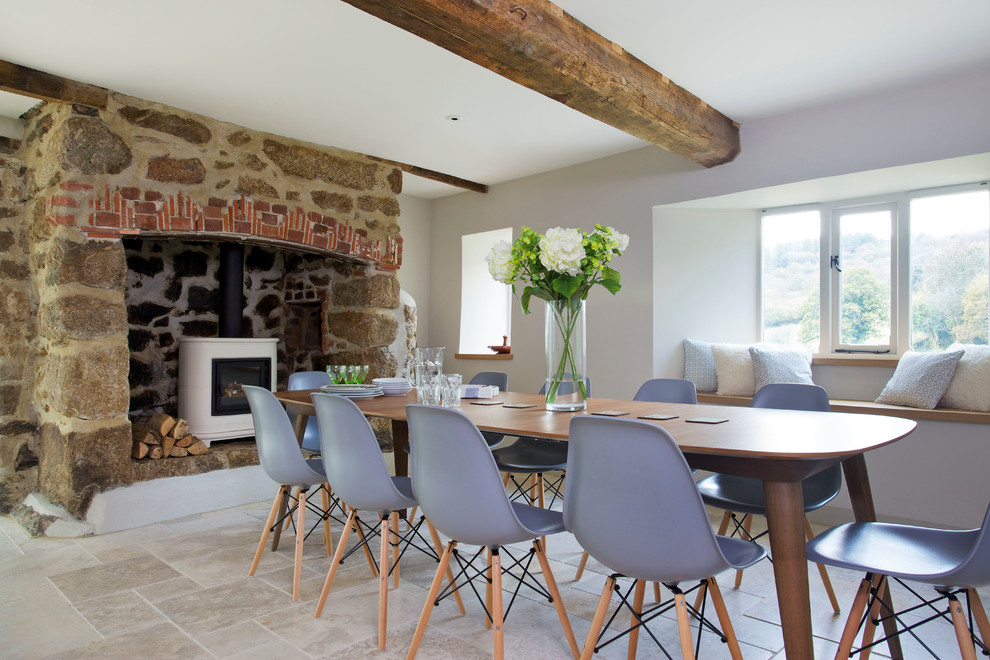 This is an example of a contemporary dining room in Devon with a wood stove.
