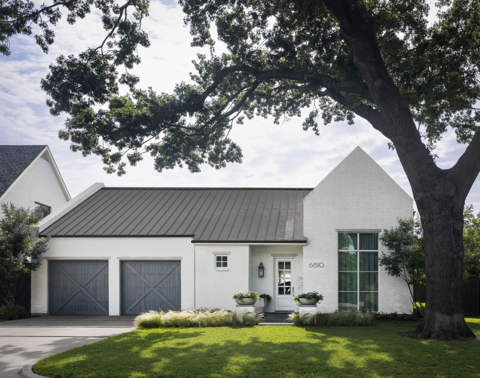 Großes, Einstöckiges Klassisches Einfamilienhaus mit gestrichenen Ziegeln, weißer Fassadenfarbe, Satteldach, Blechdach und grauem Dach in Dallas