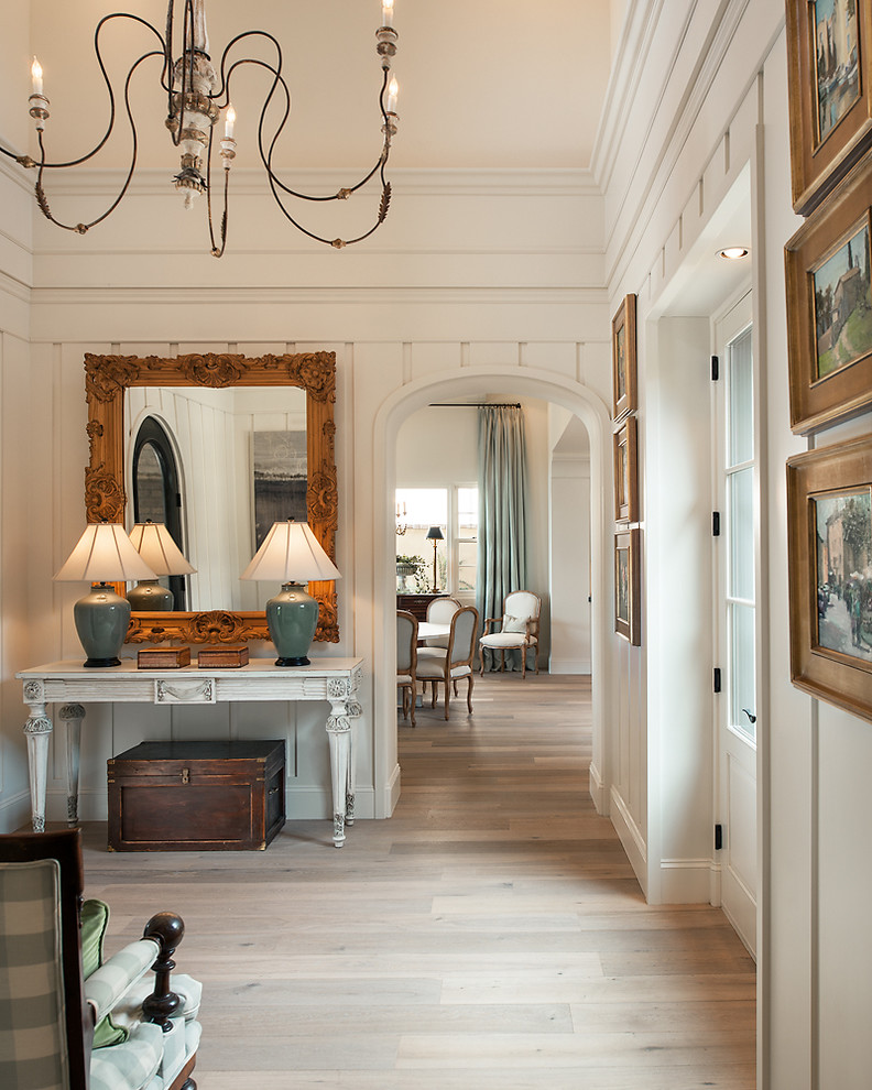 Inspiration for a traditional foyer in Phoenix with white walls, light hardwood floors and a glass front door.