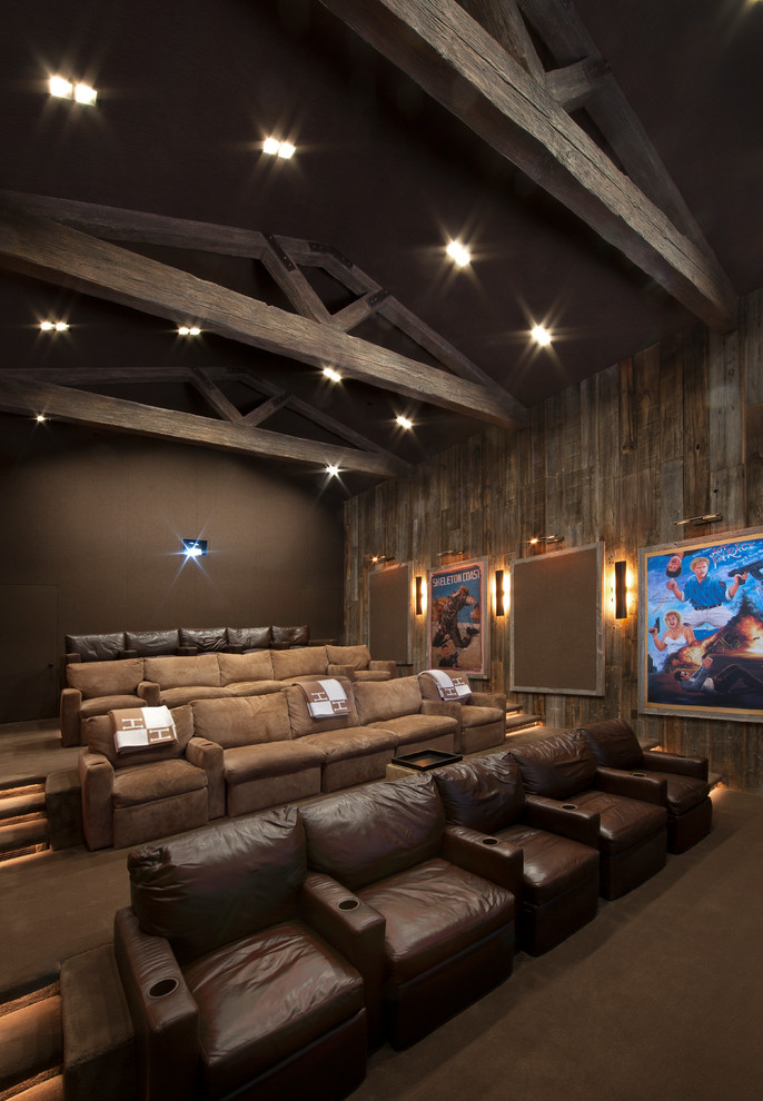 This is an example of an expansive country open concept home theatre in Los Angeles with brown walls, carpet, a projector screen and brown floor.