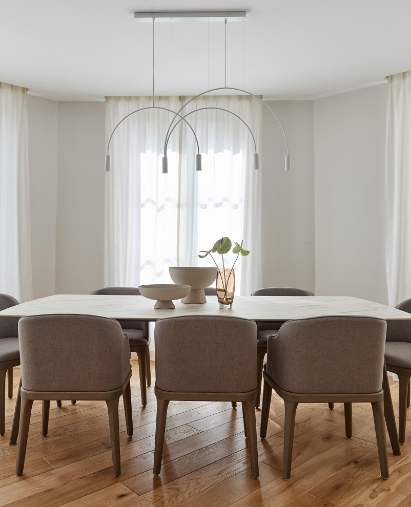 Contemporary dining room in Paris with grey walls, light hardwood floors and no fireplace.
