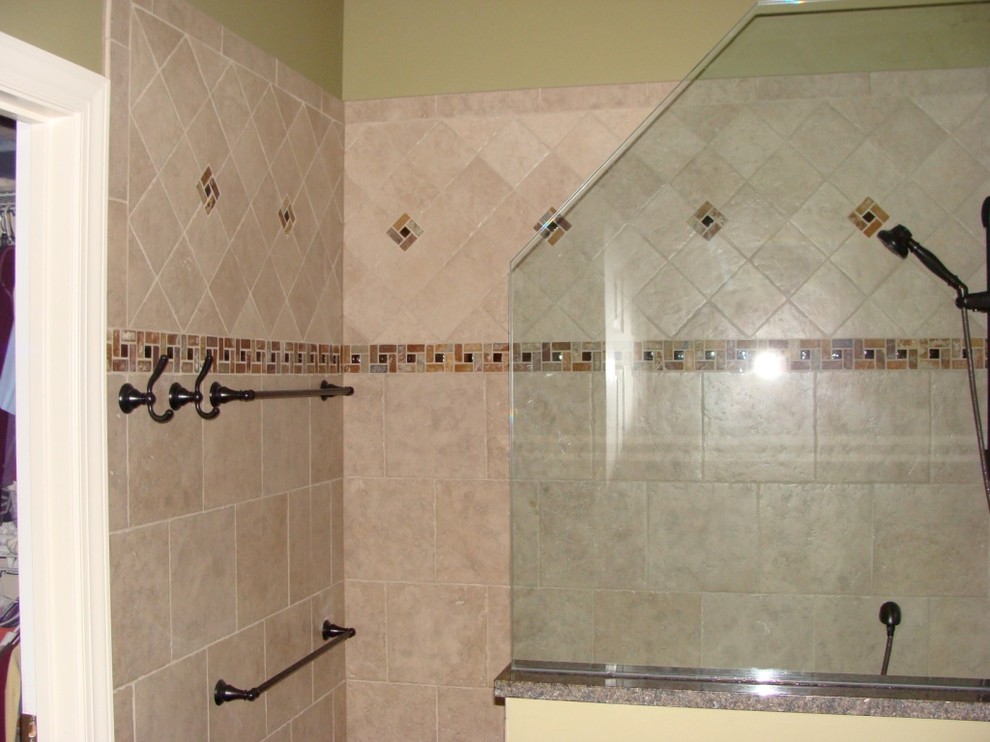 This is an example of a mid-sized traditional master bathroom in Orange County with raised-panel cabinets, dark wood cabinets, an open shower, a one-piece toilet, beige tile, brown tile, ceramic tile, yellow walls, an undermount sink and granite benchtops.