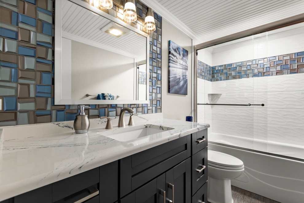 На фото: маленькая главная ванная комната в морском стиле с фасадами в стиле шейкер, синими фасадами, ванной в нише, душем в нише, унитазом-моноблоком, разноцветной плиткой, керамической плиткой, бежевыми стенами, полом из керамической плитки, врезной раковиной, столешницей из искусственного кварца, белым полом, душем с раздвижными дверями, синей столешницей, тумбой под одну раковину, напольной тумбой и потолком из вагонки для на участке и в саду