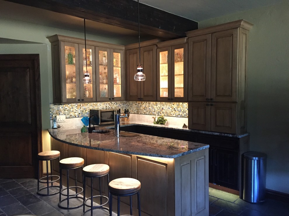 Mid-sized contemporary u-shaped seated home bar in Denver with an undermount sink, glass-front cabinets, light wood cabinets, granite benchtops, multi-coloured splashback, slate floors, mosaic tile splashback, grey floor and grey benchtop.