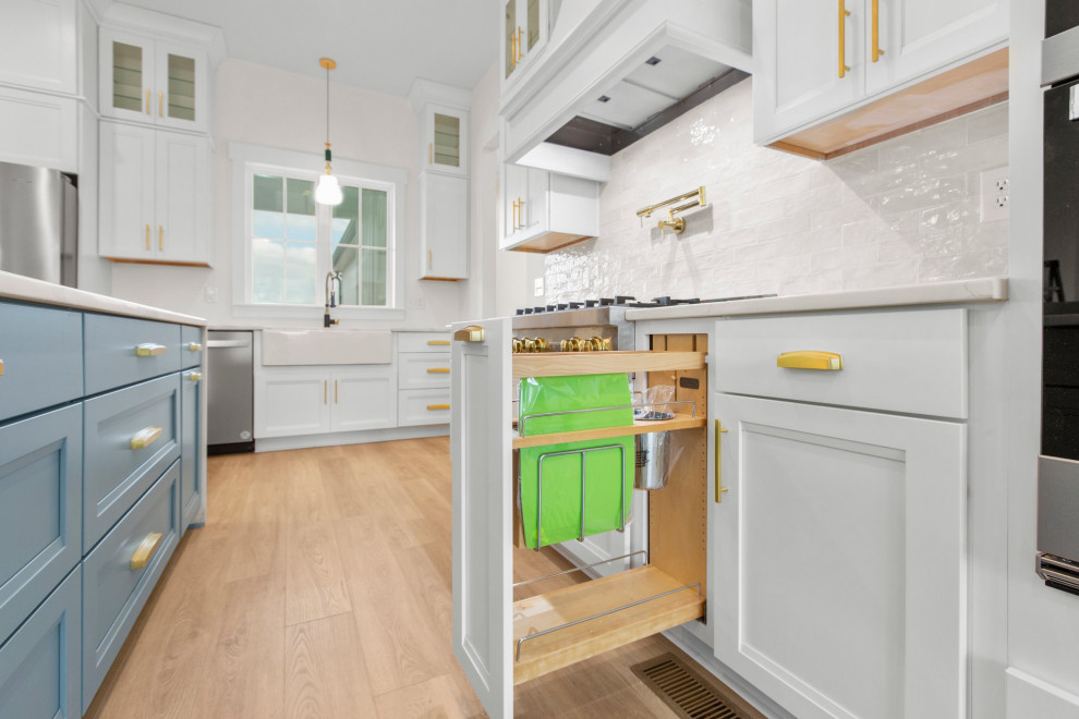 Example of a large transitional l-shaped open concept kitchen design in Richmond with a farmhouse sink, recessed-panel cabinets, quartz countertops, white backsplash, stainless steel appliances, an island and white countertops