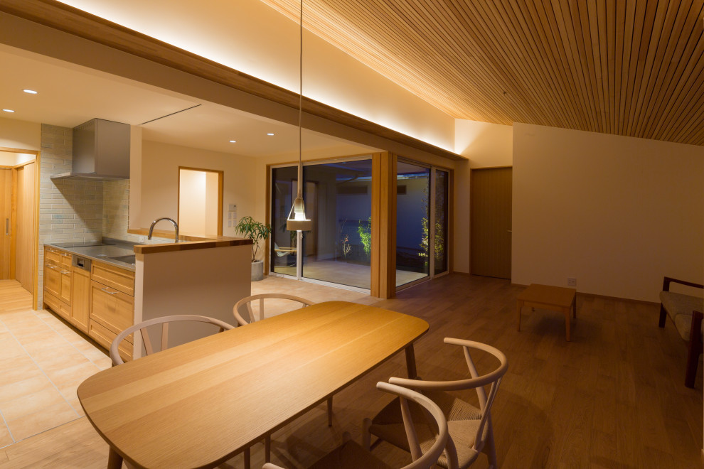 Idee per una sala da pranzo aperta verso il soggiorno scandinava di medie dimensioni con pareti bianche, parquet chiaro e soffitto in legno