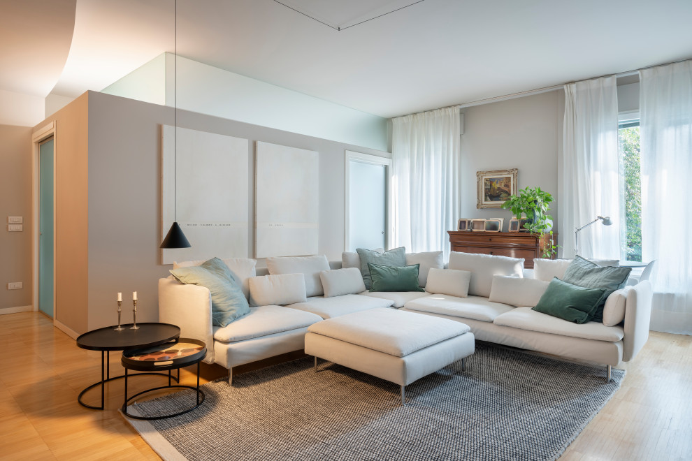Imagen de sala de estar abierta y blanca actual grande con paredes blancas, suelo de madera pintada, televisor independiente y bandeja